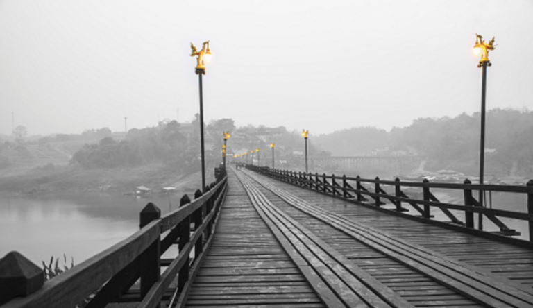 Black and white photo of bridge with gold lampost